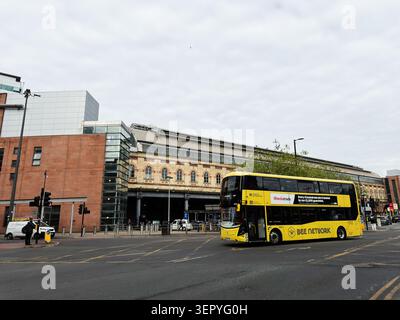 Manchester, Royaume-Uni - 07 mai 2026 : bus à impériale Yellow Bee Network près d'une gare ferroviaire animée de Manchester, des transports urbains et de l'architecture de la ville. Banque D'Images