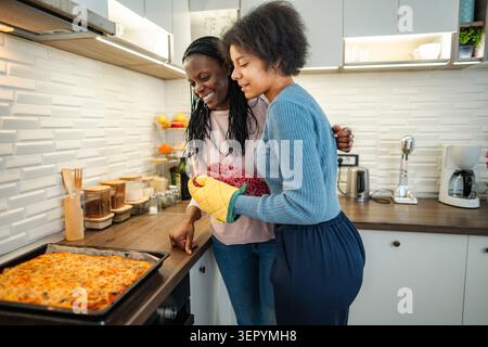 Mère et fille cuisiner ensemble des pizzas dans la cuisine à la maison Banque D'Images