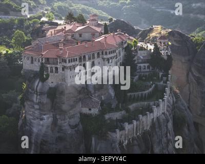 Vue aérienne du monastère historique des Météores perché sur un massif pilier rocheux avec des toits de tuiles rouges et une architecture en pierre à Trikala, en Grèce. Banque D'Images