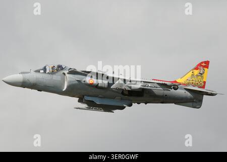 Un avion de saut AV-8B Harrier II de la marine espagnole avec une ailette arrière colorée et spécialement peinte vole horizontalement contre un ciel bleu clair. Banque D'Images