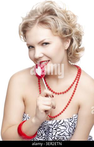Portrait isolé de belle jeune taille blonde plus modèle femme avec sucette rouge avec coeur blanc milieu Banque D'Images