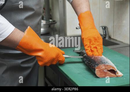 Découpage du saumon Chef de pêcher sur les steaks avec le couteau Banque D'Images