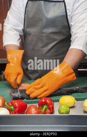 Découpage du saumon Chef de pêcher sur les steaks avec le couteau Banque D'Images