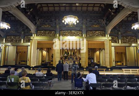 Tokyo, Japon - 23 octobre 2019 : la vue de la salle principale du temple bouddhiste Tsukiji Hongan-ji avec des gens qui prient devant l'autel avec la statue Banque D'Images