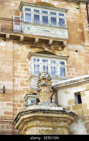 Une vue sur la vieille maison avec balcon traditionnel de style maltais et sculpture de lion sur la rue Lvant de la Valette. Malte Banque D'Images