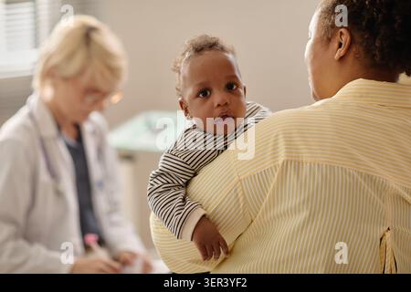 Portrait de bébé noir lors d'un rendez-vous pédiatre avec mère Banque D'Images
