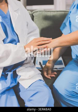 Un fournisseur de soins de santé compatissant tient la main d'un patient âgé pour offrir soutien et confort. Banque D'Images