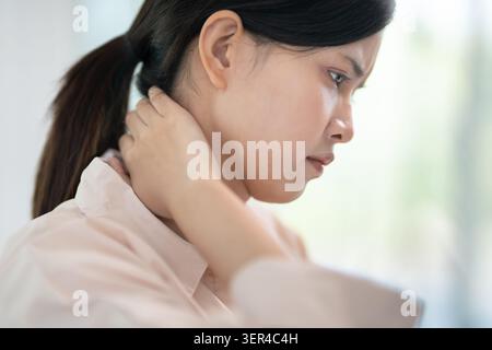 syndromes de bureau, femme massant des douleurs cervicales dues au travail et à l'aide d'un ordinateur, composite numérique d'une colonne vertébrale focalisée de douleurs cervicales et d'épaule symp Banque D'Images