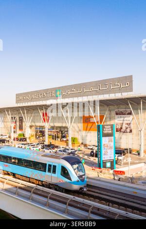 Dubaï, Émirats arabes Unis - 25 octobre 2025 : train moderne sans conducteur sur la voie surélevée du métro de Dubaï. Entrée du centre commercial Dubai Times Square Center, façade vitrée et Banque D'Images