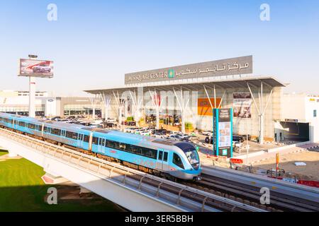 Dubaï, Émirats arabes Unis - 25 octobre 2025 : train moderne sans conducteur sur la voie surélevée du métro de Dubaï. Entrée du centre commercial Dubai Times Square Center, façade vitrée et Banque D'Images
