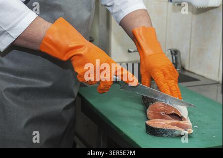 Découpage du saumon Chef de pêcher sur les steaks avec le couteau Banque D'Images