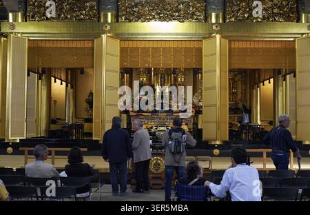 Tokyo, Japon - 23 octobre 2019 : la vue de la salle principale du temple bouddhiste Tsukiji Hongan-ji avec des gens qui prient devant l'autel avec la statue Banque D'Images