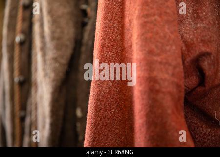 Tissu en lin naturel brun chaud suspendu dans des plis doux avec texture riche Banque D'Images