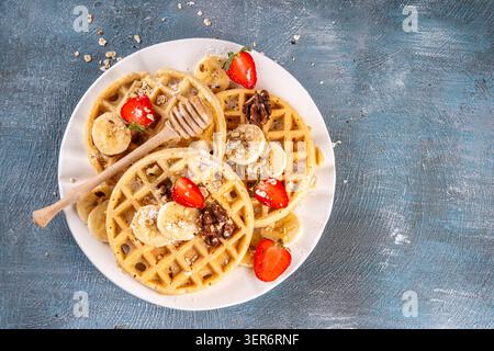 Gaufres saines d'avoine banane sans gluten avec ingrédient pour la cuisine, banane fraîche, tranches de fraises, noix et miel. Recette de gaufres belges maison Banque D'Images