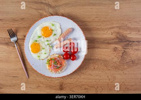 Oeufs frits avec saucisse, tomates cerises et pain de sarrasin avec saumon Banque D'Images