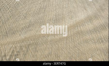 Texture pleine trame d'ondulations de sable humides formées par les vagues d'eau Banque D'Images
