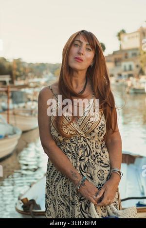 Pensive femme mature élégante profitant de la soirée d'été dans le port méditerranéen Banque D'Images