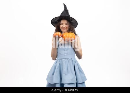 Jeune femme souriante en costume de sorcière tenant une petite citrouille Banque D'Images