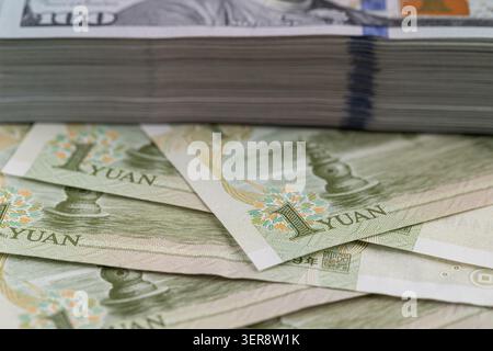 Les billets de banque chinois en yuan se rapprochent avec un fond de pile de dollars américains Banque D'Images