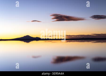 Un magnifique lever de soleil sur les plaines salines d'Uyuni en Bolivie, capturant le reflet serein du ciel. Cette aventure hors route incarne la beauté de natur Banque D'Images