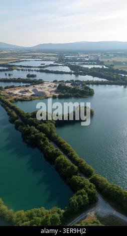 Vue aérienne montrant Lagoa da Lontra reliant plusieurs lacs, entourée d'arbres verdoyants et d'une carrière d'agrégats visible Banque D'Images