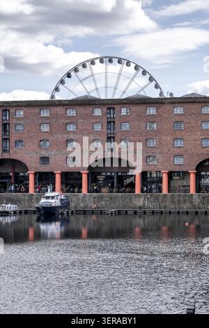 Liverpool, Royaume-Uni - 06 mai 2026 : vue sur l'historique Royal Albert Dock avec ses entrepôts en briques rouges et la roue de Liverpool qui s'élève derrière Banque D'Images