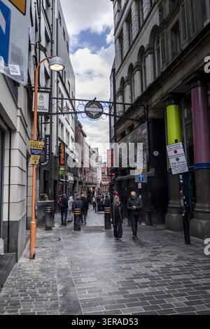 Liverpool, Royaume-Uni - 06 mai 2026 : vue de piétons marchant le long de la rue pavée historique Mathew Street dans le quartier des grottes avec des panneaux pour le Banque D'Images