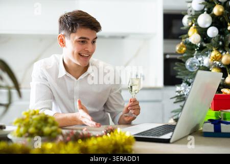 homme communique joyeusement par appel vidéo le soir du nouvel an Banque D'Images