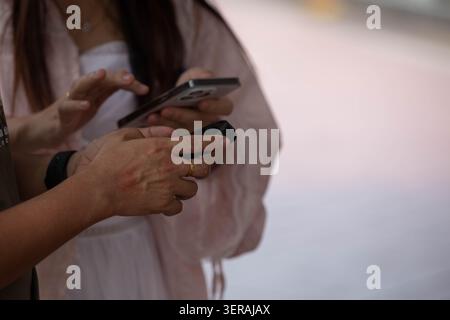 Homme et femme utilisant des smartphones ensemble, gros plan. Banque D'Images
