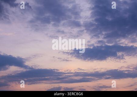 Beau ciel nocturne dramatique rempli de nuages violets et bleus pendant le coucher du soleil. Nuageux atmosphérique naturel avec des couleurs pastel douces Banque D'Images