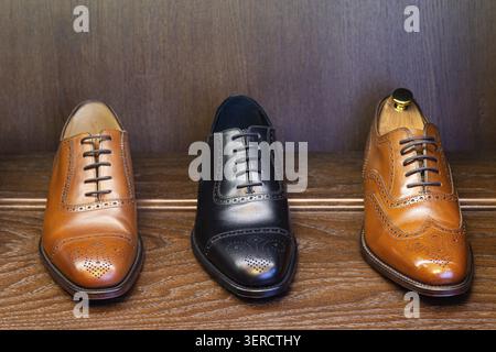 Chaussures en cuir pleine fleur noir et brun sur affichage en bois dans le magasin de chaussures homme boutique Banque D'Images