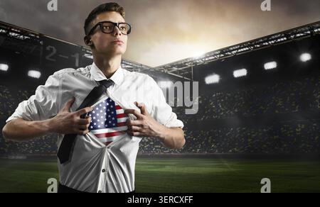 Football américain ou supporter de football montrant un drapeau sous son maillot d'affaires sur le stade Banque D'Images