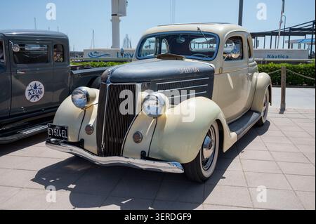 Vue de trois quarts avant d'un coupé Ford modèle 68 1936 vintage avec une carrosserie crème, un capot gris contrasté, une calandre chromée et des pneus à flanc blanc stationnés à l'extérieur Banque D'Images