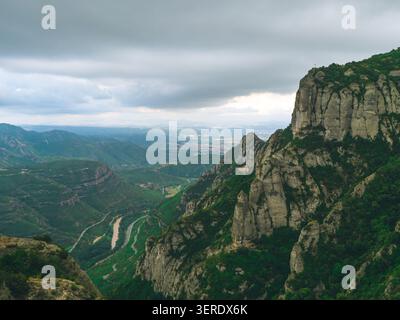 Cette superbe photo capture un paysage de montagne tranquille avec une végétation luxuriante sous un ciel couvert. La beauté naturelle des falaises est là Banque D'Images