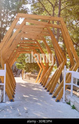 Chemin de pavillon à cadre hexagonal en bois personnalisé dans un cadre de jardin ensoleillé Banque D'Images