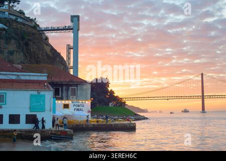 LISBONNE, PORTUGAL - nov 09, 2025 : coucher de soleil à Almada, Portugal, avec repas en plein air au bord de la rivière avec vue sur le pont du 25 avril, Boca do vent Banque D'Images