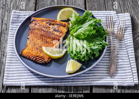 Filet de poisson grillé sec tikka au saumon avec laitue et citron sur l'assiette, vue de dessus authentique photographie de nourriture de style indien pour le restaurant, pas ai Generate Banque D'Images