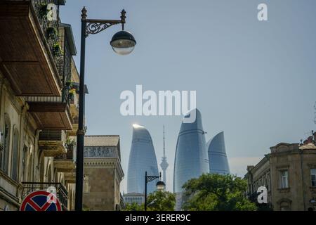 Les emblématiques Flame Towers et Bakou TV Tower s'élèvent bien au-dessus des bâtiments résidentiels traditionnels et d'un lampadaire classique dans la capitale de l'Azerbaïdjan c Banque D'Images