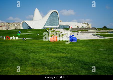 L'emblématique Heydar Aliyev Center, chef-d'œuvre de l'architecture moderne, se dresse sous un ciel bleu clair à Bakou, en Azerbaïdjan. Le parc vert environnant f Banque D'Images