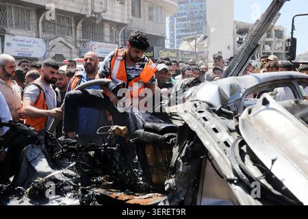 Les Palestiniens se rassemblent sur le site de la grève meurtrière de véhicules dans la ville de Gaza les Palestiniens et le personnel de la défense civile se rassemblent autour d’un véhicule détruit qui a été pris pour cible lors d’une frappe aérienne israélienne dans la ville de Gaza, le 18 juin 2026. La frappe a tué trois Palestiniens, selon des sources médicales, et a causé d'importants dégâts au véhicule. Photo de Belal Osama apaimages Gaza bande de Gaza territoire palestinien 180626 Gaza BO 1 0031 Copyright : xapaimagesxBelalxOsamaxxapaimagesx Banque D'Images