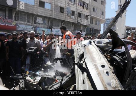 Les Palestiniens se rassemblent sur le site de la grève meurtrière de véhicules dans la ville de Gaza les Palestiniens et le personnel de la défense civile se rassemblent autour d’un véhicule détruit qui a été pris pour cible lors d’une frappe aérienne israélienne dans la ville de Gaza, le 18 juin 2026. La frappe a tué trois Palestiniens, selon des sources médicales, et a causé d'importants dégâts au véhicule. Photo de Belal Osama apaimages Gaza bande de Gaza territoire palestinien 180626 Gaza BO 1 0029 Copyright : xapaimagesxBelalxOsamaxxapaimagesx Banque D'Images