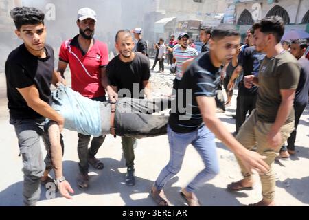 Les Palestiniens se rassemblent sur le site de la grève meurtrière de véhicules dans la ville de Gaza les Palestiniens et le personnel de la défense civile se rassemblent autour d’un véhicule détruit qui a été pris pour cible lors d’une frappe aérienne israélienne dans la ville de Gaza, le 18 juin 2026. La frappe a tué trois Palestiniens, selon des sources médicales, et a causé d'importants dégâts au véhicule. Photo de Belal Osama apaimages Gaza bande de Gaza territoire palestinien 180626 Gaza BO 1 007 Copyright : xapaimagesxBelalxOsamaxxapaimagesx Banque D'Images