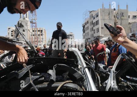 Les Palestiniens se rassemblent sur le site de la grève meurtrière de véhicules dans la ville de Gaza les Palestiniens et le personnel de la défense civile se rassemblent autour d’un véhicule détruit qui a été pris pour cible lors d’une frappe aérienne israélienne dans la ville de Gaza, le 18 juin 2026. La frappe a tué trois Palestiniens, selon des sources médicales, et a causé d'importants dégâts au véhicule. Photo de Belal Osama apaimages Gaza bande de Gaza territoire palestinien 180626 Gaza BO 1 0032 Copyright : xapaimagesxBelalxOsamaxxapaimagesx Banque D'Images