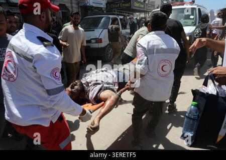 Les Palestiniens se rassemblent sur le site de la grève meurtrière de véhicules dans la ville de Gaza les Palestiniens et le personnel de la défense civile se rassemblent autour d’un véhicule détruit qui a été pris pour cible lors d’une frappe aérienne israélienne dans la ville de Gaza, le 18 juin 2026. La frappe a tué trois Palestiniens, selon des sources médicales, et a causé d'importants dégâts au véhicule. Photo de Belal Osama apaimages Gaza bande de Gaza territoire palestinien 180626 Gaza BO 1 0018 Copyright : xapaimagesxBelalxOsamaxxapaimagesx Banque D'Images