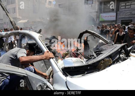 Les Palestiniens se rassemblent sur le site de la grève meurtrière de véhicules dans la ville de Gaza les Palestiniens et le personnel de la défense civile se rassemblent autour d’un véhicule détruit qui a été pris pour cible lors d’une frappe aérienne israélienne dans la ville de Gaza, le 18 juin 2026. La frappe a tué trois Palestiniens, selon des sources médicales, et a causé d'importants dégâts au véhicule. Photo de Belal Osama apaimages Gaza bande de Gaza territoire palestinien 180626 Gaza BO 1 009 Copyright : xapaimagesxBelalxOsamaxxapaimagesx Banque D'Images