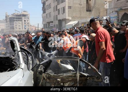 Les Palestiniens se rassemblent sur le site de la grève meurtrière de véhicules dans la ville de Gaza les Palestiniens et le personnel de la défense civile se rassemblent autour d’un véhicule détruit qui a été pris pour cible lors d’une frappe aérienne israélienne dans la ville de Gaza, le 18 juin 2026. La frappe a tué trois Palestiniens, selon des sources médicales, et a causé d'importants dégâts au véhicule. Photo de Belal Osama apaimages Gaza bande de Gaza territoire palestinien 180626 Gaza BO 1 0021 Copyright : xapaimagesxBelalxOsamaxxapaimagesx Banque D'Images