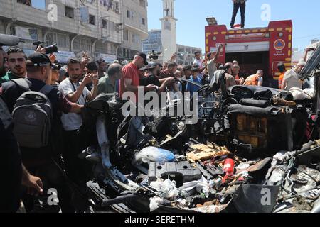 Les Palestiniens se rassemblent sur le site de la grève meurtrière de véhicules dans la ville de Gaza les Palestiniens et le personnel de la défense civile se rassemblent autour d’un véhicule détruit qui a été pris pour cible lors d’une frappe aérienne israélienne dans la ville de Gaza, le 18 juin 2026. La frappe a tué trois Palestiniens, selon des sources médicales, et a causé d'importants dégâts au véhicule. Photo de Belal Osama apaimages Gaza bande de Gaza territoire palestinien 180626 Gaza BO 1 0038 Copyright : xapaimagesxBelalxOsamaxxapaimagesx Banque D'Images