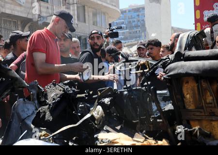 Les Palestiniens se rassemblent sur le site de la grève meurtrière de véhicules dans la ville de Gaza les Palestiniens et le personnel de la défense civile se rassemblent autour d’un véhicule détruit qui a été pris pour cible lors d’une frappe aérienne israélienne dans la ville de Gaza, le 18 juin 2026. La frappe a tué trois Palestiniens, selon des sources médicales, et a causé d'importants dégâts au véhicule. Photo de Belal Osama apaimages Gaza bande de Gaza territoire palestinien 180626 Gaza BO 1 0040 Copyright : xapaimagesxBelalxOsamaxxapaimagesx Banque D'Images