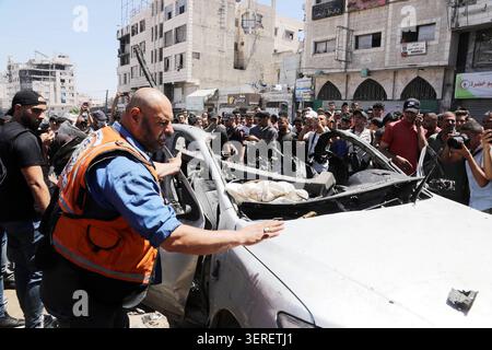Les Palestiniens se rassemblent sur le site de la grève meurtrière de véhicules dans la ville de Gaza les Palestiniens et le personnel de la défense civile se rassemblent autour d’un véhicule détruit qui a été pris pour cible lors d’une frappe aérienne israélienne dans la ville de Gaza, le 18 juin 2026. La frappe a tué trois Palestiniens, selon des sources médicales, et a causé d'importants dégâts au véhicule. Photo de Belal Osama apaimages Gaza bande de Gaza territoire palestinien 180626 Gaza BO 1 0047 Copyright : xapaimagesxBelalxOsamaxxapaimagesx Banque D'Images