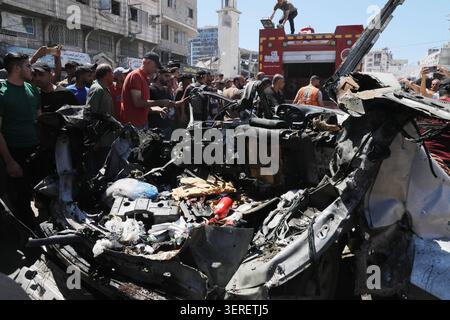 Les Palestiniens se rassemblent sur le site de la grève meurtrière de véhicules dans la ville de Gaza les Palestiniens et le personnel de la défense civile se rassemblent autour d’un véhicule détruit qui a été pris pour cible lors d’une frappe aérienne israélienne dans la ville de Gaza, le 18 juin 2026. La frappe a tué trois Palestiniens, selon des sources médicales, et a causé d'importants dégâts au véhicule. Photo de Belal Osama apaimages Gaza bande de Gaza territoire palestinien 180626 Gaza BO 1 0041 Copyright : xapaimagesxBelalxOsamaxxapaimagesx Banque D'Images